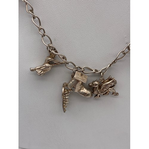 368 - SILVER TWIST LINK NECKLACE WITH EIGHT NOVELTY CHARMS 31G APPROX