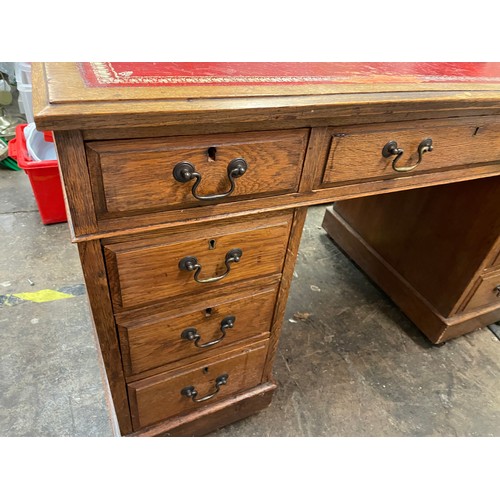 27 - LATE VICTORIAN OAK NINE DRAWER KNEEHOLE DESK WITH RED LEATHER INSET SCIVER