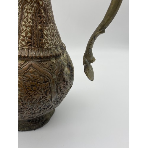 567 - EASTERN COPPER AND BRASS HANDLED ENGRAVED EWER