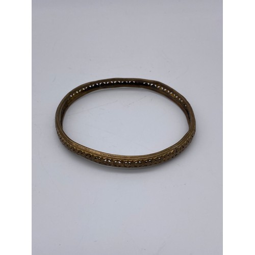 690 - THREE PLATED AND GOLD TONE COLOURED BANGLES (INC. BADEN EXAMPLE) AND AN ORNATE BONE BANGLE WITH RED ... 