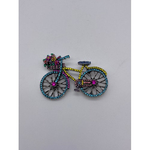 671 - MULTI COLOURED STONE ENCRUSTED BICYCLE DRESS BROOCH