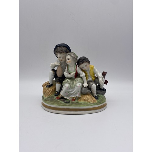 609 - CONTINENTAL PORCELAIN FIGURE GROUP OF CHILDREN IN THE 18TH CENTURY STYLE