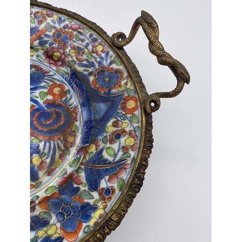 633 - CHINESE POTTERY PLATE CONVERTED TO SERVING TRAY WITH GILT METAL TWIN HANDLED SERPENT DESIGN A/F