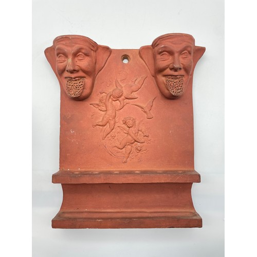 610 - TERRACOTTA FACE MASK AND CHERUB WALL PLAQUE