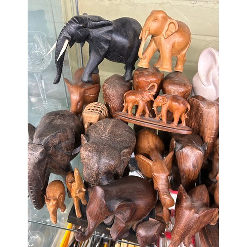 223 - SHELF OF CARVED WOODEN POTTERY AND RESIN ELEPHANT FIGURES