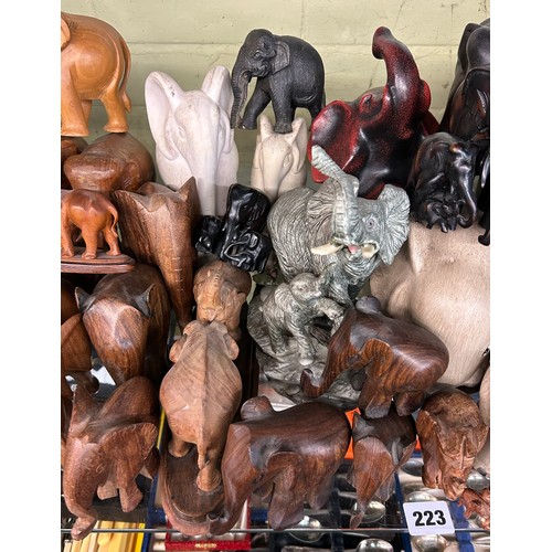 223 - SHELF OF CARVED WOODEN POTTERY AND RESIN ELEPHANT FIGURES