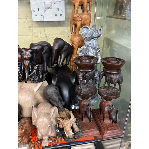 223 - SHELF OF CARVED WOODEN POTTERY AND RESIN ELEPHANT FIGURES