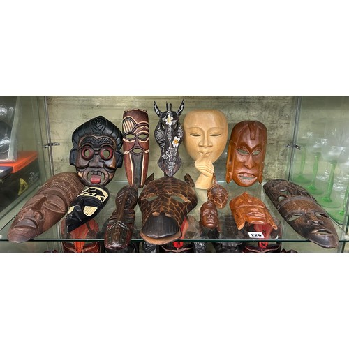 226 - SHELF OF CARVED AFRICAN SOUVENIR FACE MASKS