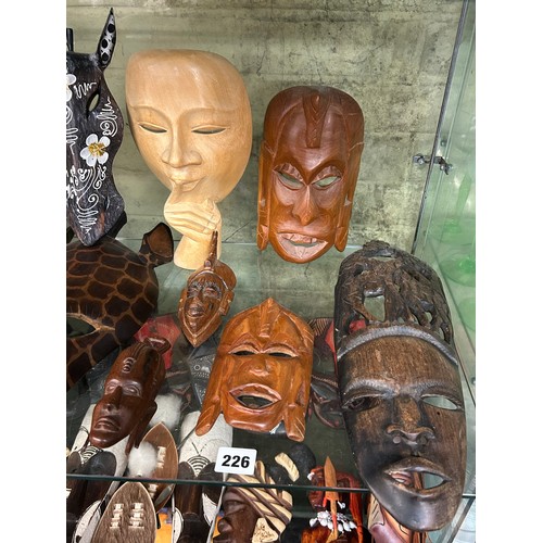 226 - SHELF OF CARVED AFRICAN SOUVENIR FACE MASKS