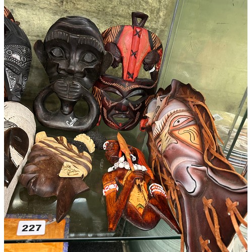 227 - SHELF OF CARVED AFRICAN SOUVENIR FACE MASKS