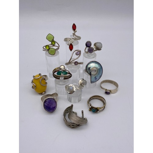 455 - SELECTION OF SILVER AND WHITE METAL CABOCHON AND POLISHED STONE ENCRUSTED DRESS RINGS