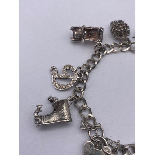 455 - SMALL SILVER AND WHITE METAL NOVELTY CHARM BRACELET