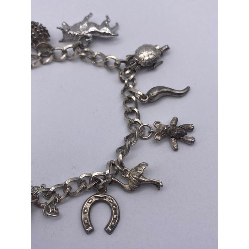 455 - SMALL SILVER AND WHITE METAL NOVELTY CHARM BRACELET