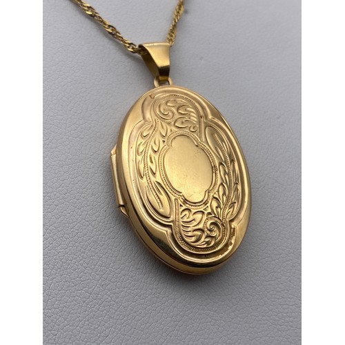 435 - 9CT GOLD OVAL ENGRAVED LOCKET ON A 9KT FINE TRACE CHAIN 6.5G APPROX