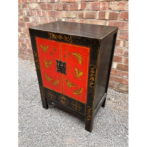 21 - CHINESE INFLUENCED RED AND BLACK LACQUERED TWO DOOR CABINET