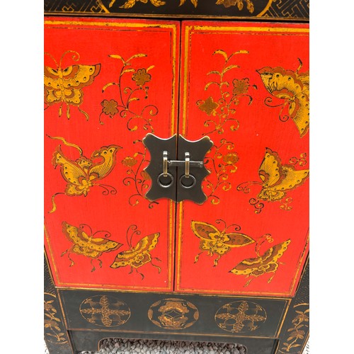 21 - CHINESE INFLUENCED RED AND BLACK LACQUERED TWO DOOR CABINET