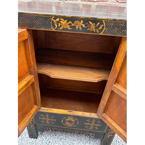 21 - CHINESE INFLUENCED RED AND BLACK LACQUERED TWO DOOR CABINET