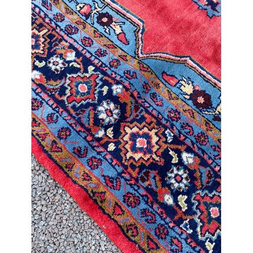 6 - EARLY 20TH CENTURY CAUCASIAN CARPET WITH CENTRAL MULTI PATTERNED MEDALLION ON A RED GROUND WITHIN MU... 