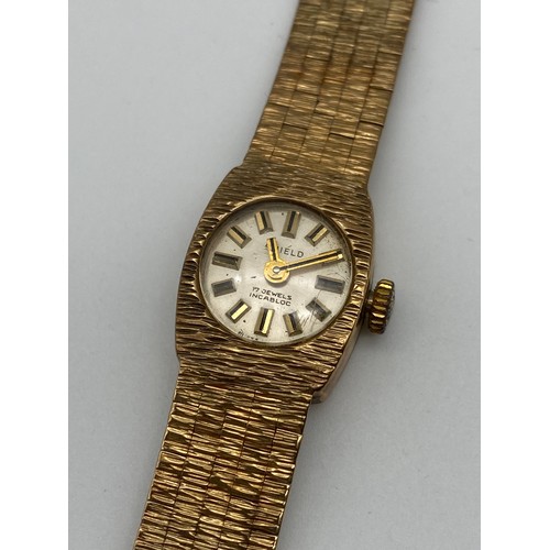 568 - LADIES SHIELD 9CT GOLD 17 JEWEL WRISTWATCH ON TEXTURED 9CT GOLD STRAP 24G