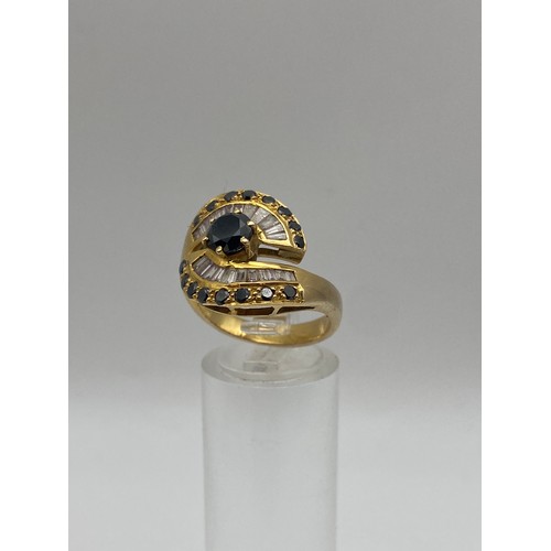 646 - STAMPED 18K SAPPHIRE AND DIAMOND BAGUETTE SET CROSSOVER RING SIZE P 8.2G APPROX