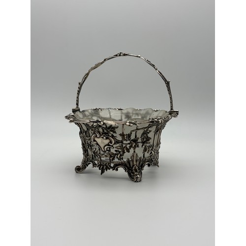 529 - 19TH CENTURY LONDON SILVER GLASS LINED BASKET WITH SWING HANDLE DECORATED WITH ACORNS ON TURNED FEET...