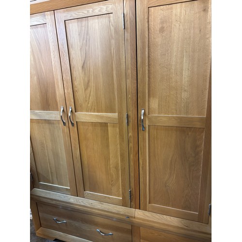 32 - LIGHT OAK THREE PANELLED DOOR WARDROBE WITH DRAWER BASE