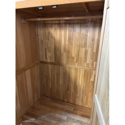 32 - LIGHT OAK THREE PANELLED DOOR WARDROBE WITH DRAWER BASE