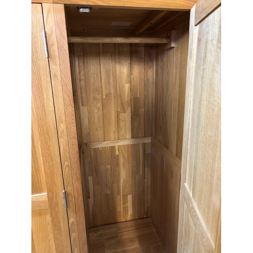 32 - LIGHT OAK THREE PANELLED DOOR WARDROBE WITH DRAWER BASE