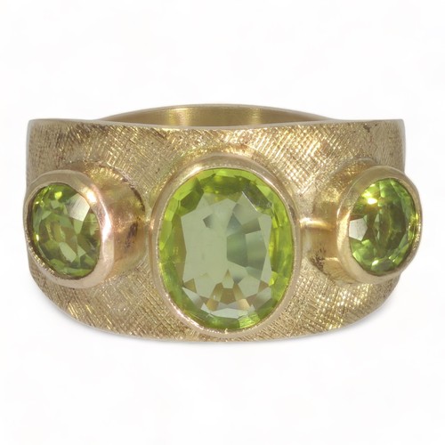 95 - A 9ct yellow gold three stone peridot set dress ring.
One oval faceted peridot measuring approx. 9mm... 