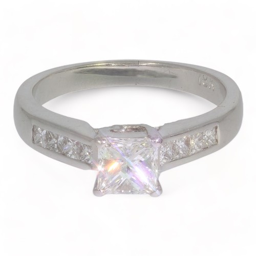 101 - A single stone princess cut diamond ring with diamond set shoulders.
Centre process cut diamond appr... 