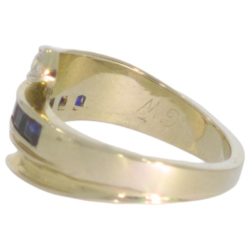 273 - Sapphire and diamond dress ring. Set with calibre cut sapphires, and a brilliant cut diamond of 0.08... 