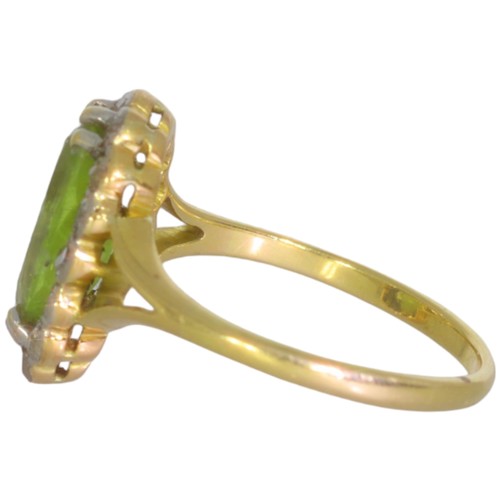 124 - An early 20th century peridot and diamond cluster ring. Set with an oval cut peridot, and brilliant ... 