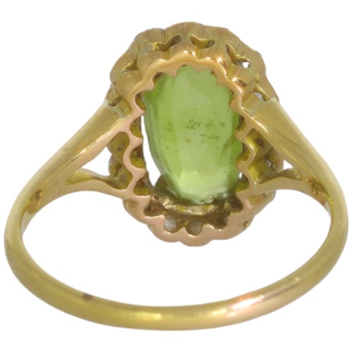 124 - An early 20th century peridot and diamond cluster ring. Set with an oval cut peridot, and brilliant ... 