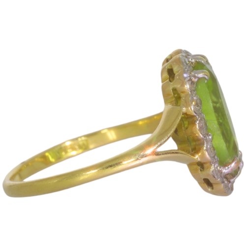 124 - An early 20th century peridot and diamond cluster ring. Set with an oval cut peridot, and brilliant ... 