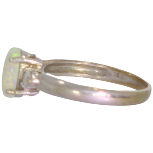 73 - 9ct white gold opal and diamond three stone ring. Set with an oval cabochon opal, and brilliant cut ... 