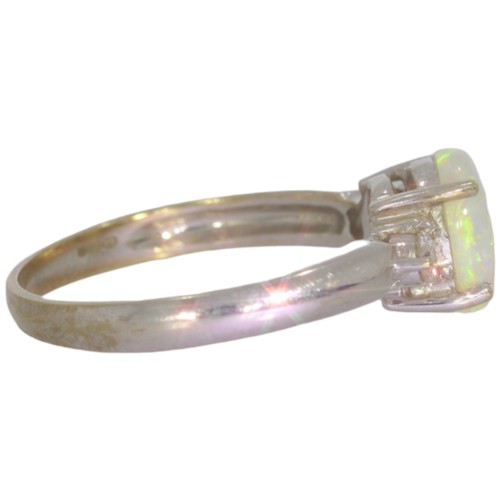 73 - 9ct white gold opal and diamond three stone ring. Set with an oval cabochon opal, and brilliant cut ... 