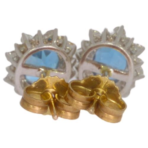 70 - 9ct gold topaz and diamond cluster earrings. Set with two oval blue topaz, and brilliant cut diamond... 