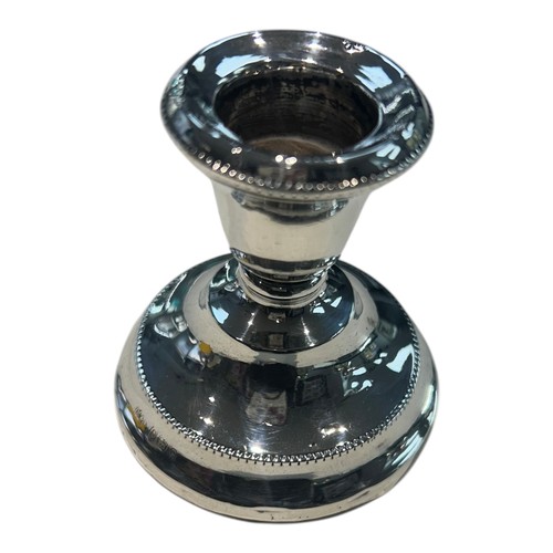 A vintage Elizabeth II sterling silver dwarf candlestick by W.I. Broadway & Co, hallmarked Birmingham, 1968. Of stepped circular form, the holder features a classic beaded gadroon border to both the flared rim and the base. A polished, weighted piece designed for stability, representing the enduring appeal of traditional English silver design in the mid-20th century.

Maker: W.I. Broadway & Co.

Origin: Birmingham, UK.

Year: 1968.

Dimensions: Height 6.5cm; Base Diameter 6cm.

Condition: Excellent vintage condition; the silver maintains a high mirror-luster and the hallmarks are exceptionally crisp.

Auctioneer's Note: Broadway & Co are celebrated for their functional elegance. This 1968 candlestick is a perfect "stocking filler" or introductory piece for a burgeoning silver collection, combining a small footprint with significant decorative impact.