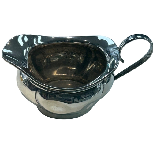 283 - A George V sterling silver cream jug of bulbous circular form, featuring a broad pouring lip and an ... 