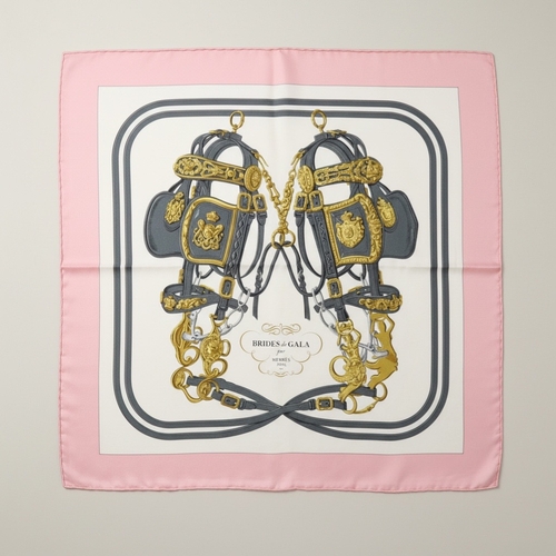 Hermès, Paris: "Brides de Gala" Carré 90 Silk Twill Scarf, Designed by Hugo Grygkar

An undeniable icon of Hermès artistry, this "Brides de Gala" Carré 90 silk twill scarf is one of the most celebrated designs in the brand's history, originally conceived by Hugo Grygkar in 1957. This iteration features the instantly recognizable central motif of two meticulously detailed horse bridles, presented in sophisticated grey and gold tones on a crisp white ground, all framed by a charming soft pink border. A timeless and elegant accessory, this authentic Hermès scarf is a must-have for collectors and a versatile statement piece for any wardrobe.