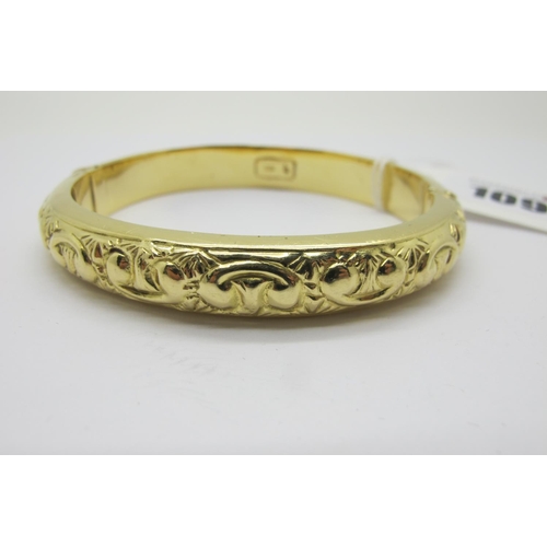 109 - A Modern Bangle, allover detailed in relief, hinged to snap clasp, stamped 