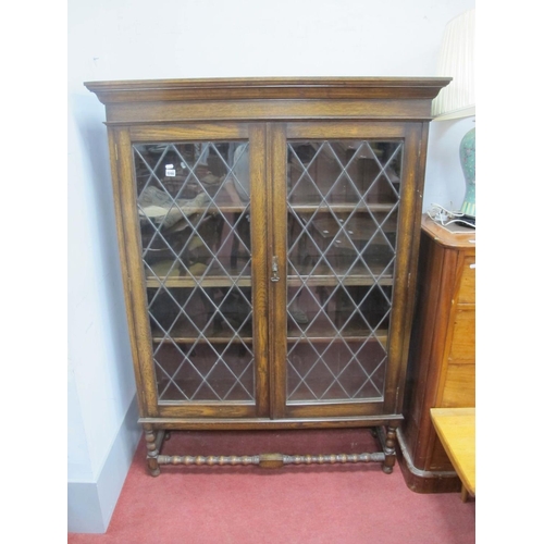 1590 - A 1920's Oak Display Cabinet, with stepped pediment, leaded glazed doors, on bobbin supports and str... 