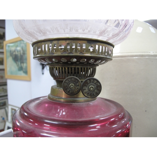 1402 - A Brass Oil Lamp, circa 1900 with eighteen facets to cranberry glass well, etched and tinted shade.