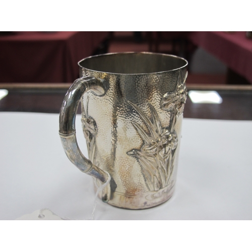 1093 - An Early XX Century Japanese Silver Mug, of tapered form cast with Iris flowers against a hammered g... 