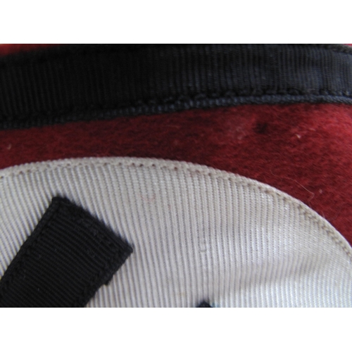 473 - A Third Reich SS Armband, red material, with central stitched white, roundel panel, black swastika a... 