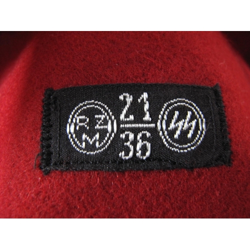 473 - A Third Reich SS Armband, red material, with central stitched white, roundel panel, black swastika a... 