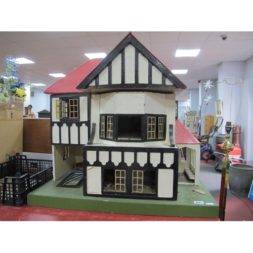 1062 - A Child's Dolls House, with red roof, timber fronted, on a green base.