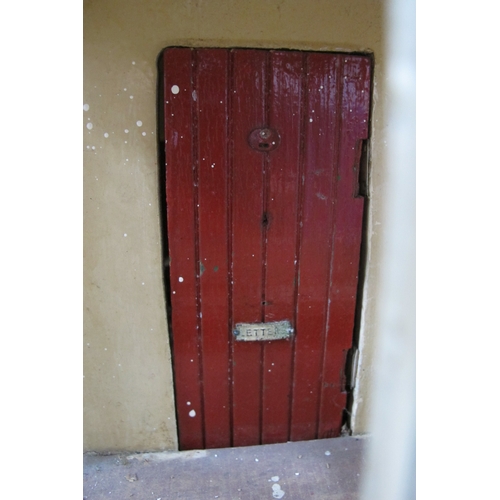 1062 - A Child's Dolls House, with red roof, timber fronted, on a green base.