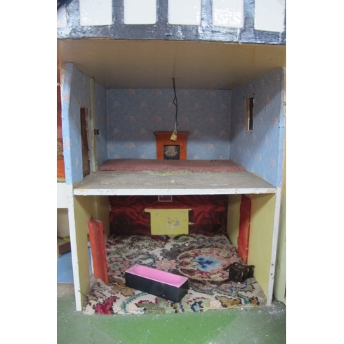 1062 - A Child's Dolls House, with red roof, timber fronted, on a green base.