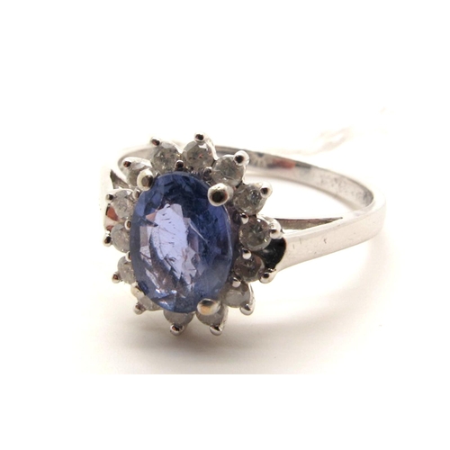 134 - A Modern 9ct White Gold Sapphire and Diamond Cluster Ring, oval four claw set to the centre, within ... 